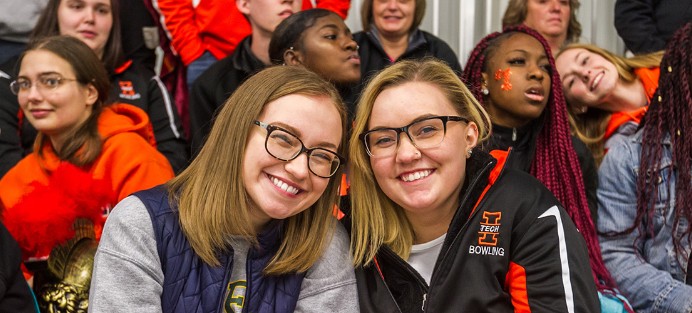 Two students sitting together while attending a sport event at Indiana Tech